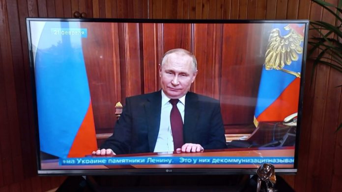 Фото экрана телевизора, на котором Владимир Путин выступает с обращением к нации. 21 февраля 2022 года