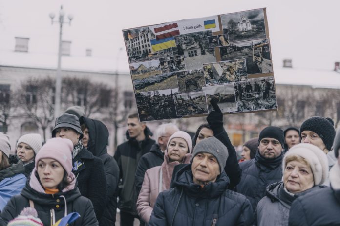 На пикет в поддержку Украины в Даугавпилсе пришли немногим более ста человек. 24 февраля 2023 года. Фото: Евгений Ратков