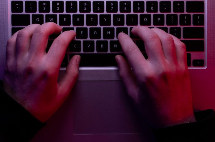 man-uses-laptop-closeup-male-hands-neon-lighting-top-view письма с угрозами