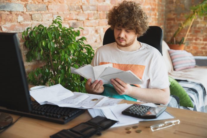 portrait-caucasian-unset-despair-man-watching-financial-economical-graphs-during-coronavirus-quarantine-problems счета