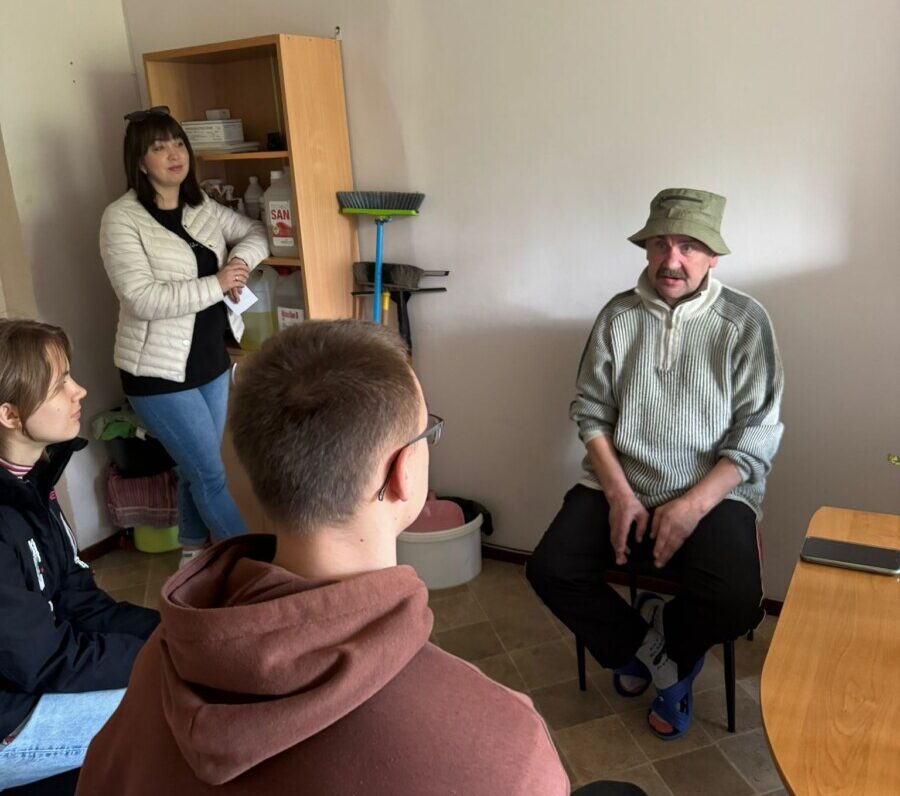 Участники проекта "НАДЕЖДА: бездомные тоже люди" беседуют с жителем приюта в Даугавпилсе Игорем. Фото сделано участниками проекта