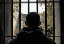 Заключённый за решёткой. Иллюстративное изображение, созданное с помощью openart.ai