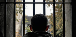 Заключённый за решёткой. Иллюстративное изображение, созданное с помощью openart.ai