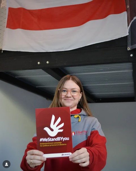 Айя Стаценко показывает листовку адвокационной кампании #WeStandBYyou. Фото: Libereco