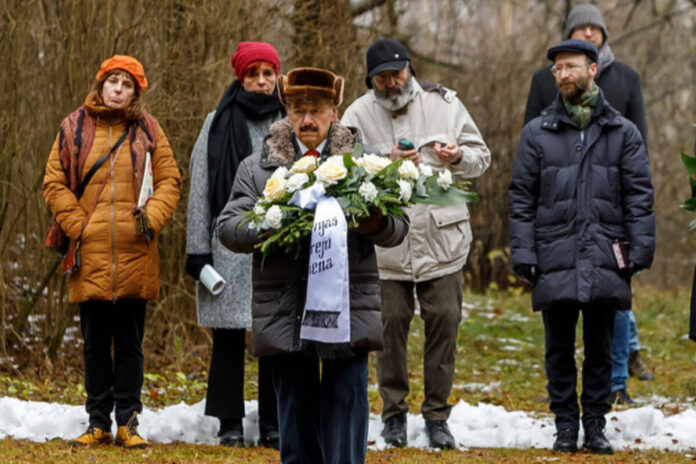 Шелли Сандерс (слева, в оранжевой куртке) на памятном мероприятии, посвящённом 84-й годовщине массовых убийств евреев в Румбуле. Румбульский лес, 30 ноября 2025 года. Фото: Марат Гришин Шелли Сандерс (слева, в оранжевой куртке) на памятном мероприятии, посвящённом 84-й годовщине массовых убийств евреев в Румбуле. Румбульский лес, 30 ноября 2025 года. Фото: Марат Гришин