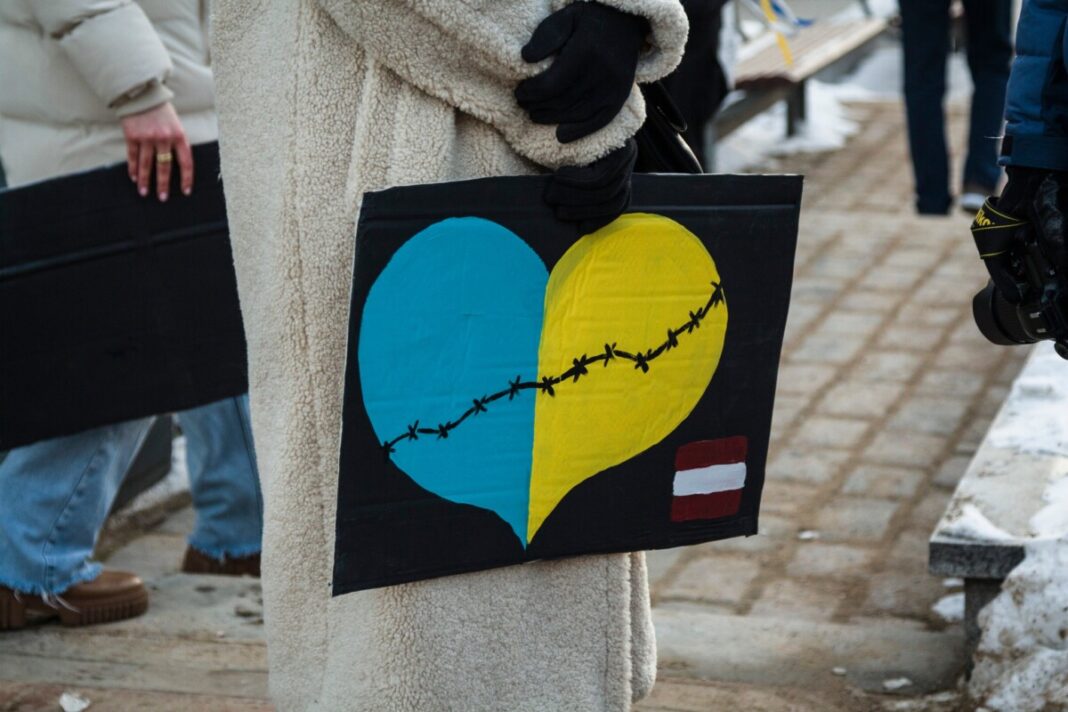 Девушка с плакатом на шествии в поддержку Украины в Даугавпилсе. 24 февраля 2025 года, третья годовщина войны. Фото: Виктория Кравцова