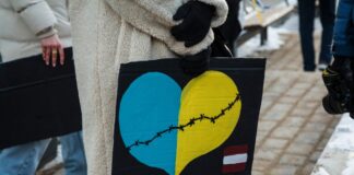 Поддержку украинцев в Латвии сократят почти на 25 млн евро. Рассказываем, что изменится в 2026 году Девушка с плакатом на шествии в поддержку Украины в Даугавпилсе. 24 февраля 2025 года, третья годовщина войны. Фото: Виктория Кравцова