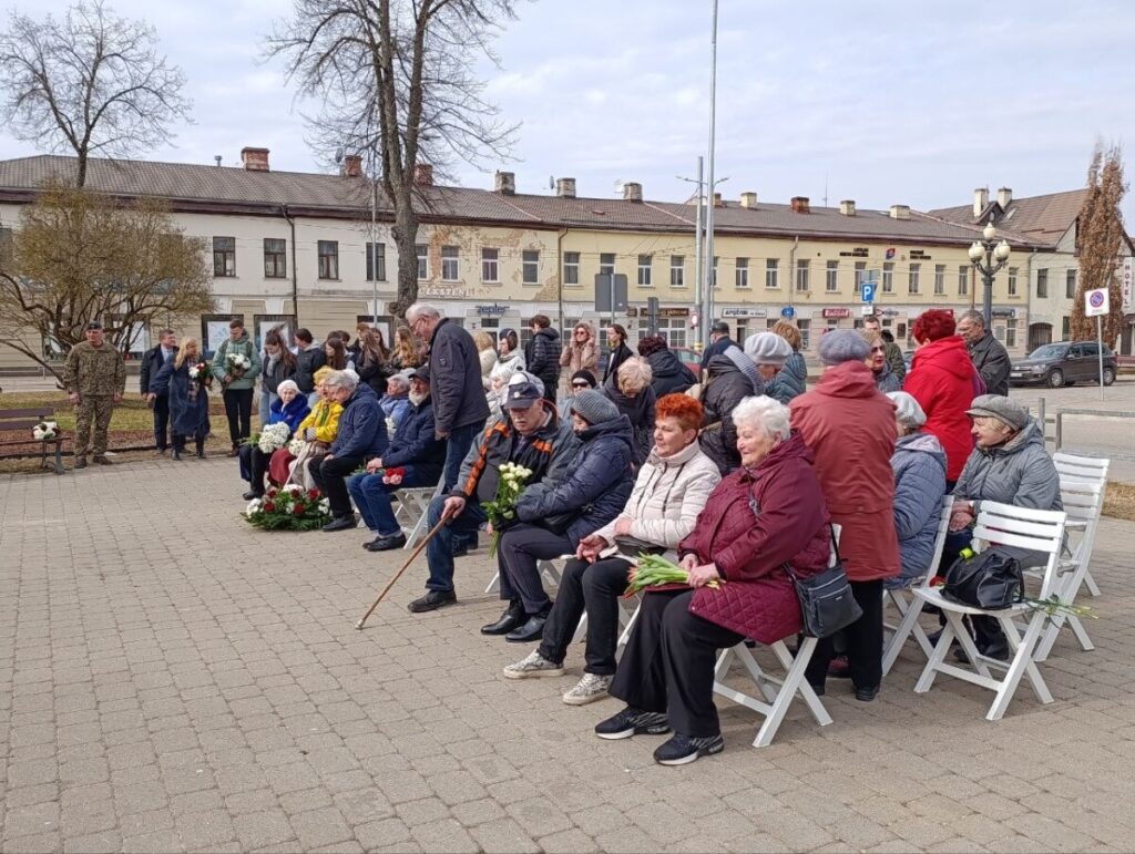Участники мероприятия, посвящённого Дню памяти коммунистического террора, возлагают цветы к мемориальному камню в сквере Андрея Пумпура. Даугавпилс, 25 марта 2026 года. Фото: Эвита Савицкая