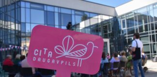 Логотип общества Cita Daugavpils в руке у участницы ретрита neRīga, bet cerīga, организованного обществом 22 августа 2025 года во дворе Даугавпилсской средней школы дизайна и искусства «Саулес». Фото: Cita Daugavpils